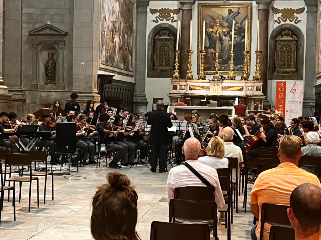 Student orchestra performing inside a historic European cathedral