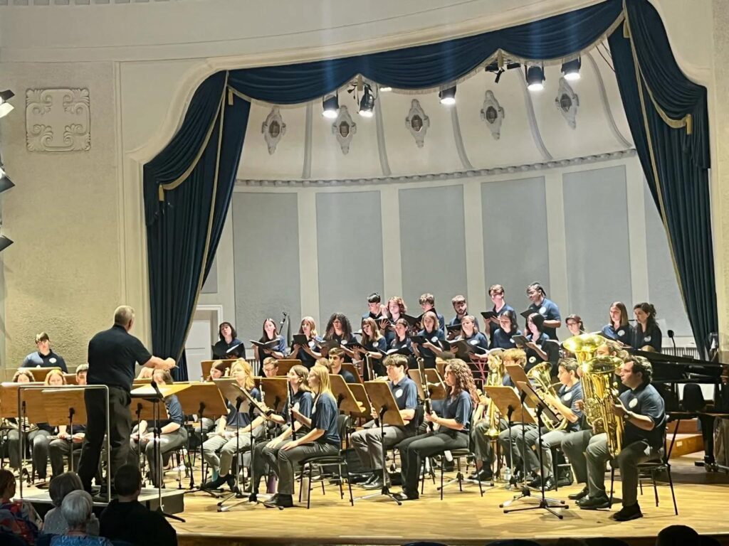College music ensemble performing in a formal European concert hall