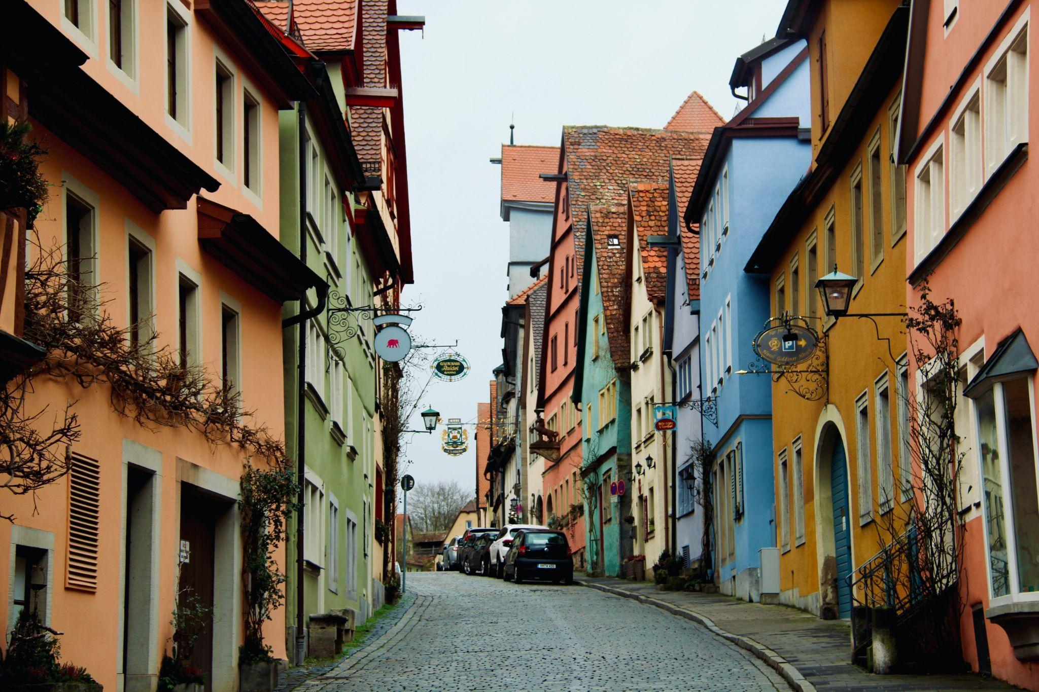 Colorful historic buildings along a cobblestone street in Rothenburg, Germany.