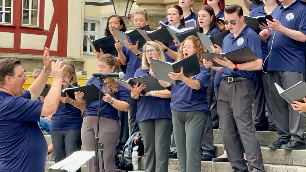 Adult choir performing during an outdoor concert in Europe