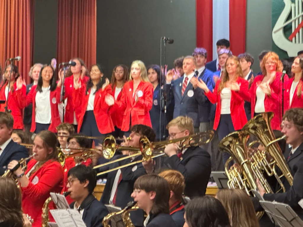 High school musicians performing together on stage as a unified ensemble during a music performance tour in Europe.