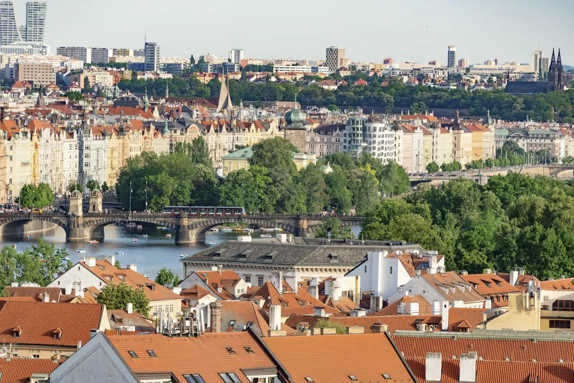 Cityscape of Prague with historic buildings and bridges over the Vltava River.