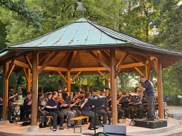Young musicians bring live performance energy to a scenic outdoor concert setting.