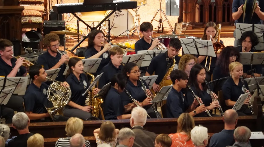 Student wind ensemble performing before an audience in a historic venue during an American Music Abroad music tour.